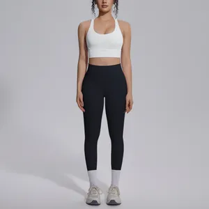 Front view of a model wearing a white sports bra and black high-waisted yoga leggings