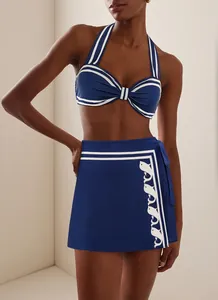 Vue détaillée d'un bikini dos nu bleu marine et d'une jupe portefeuille avec motifs poissons
