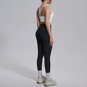 Side-back view of black high-waist yoga leggings with white cross-back sports bra