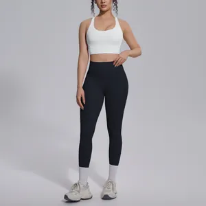Full-length view of white sports bra and black high-waisted yoga leggings on model