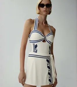 Maillot de bain une pièce licou bleu marine élégant avec jupe portefeuille et motifs poissons.