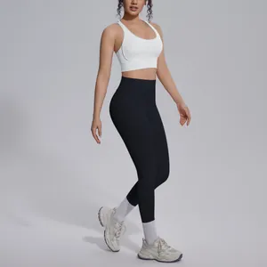 Close-up detail of high-waisted black yoga leggings and white supportive sports bra.