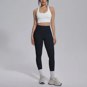 Detail shot of white sports bra and black leggings set for yoga and fitness training.