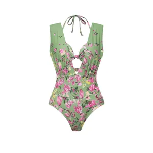 Vue détaillée d'un maillot de bain une pièce vert avec un imprimé floral rose élégant.