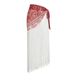 Detail view of ethnic style red patterned wrap skirt with long white fringe tassels