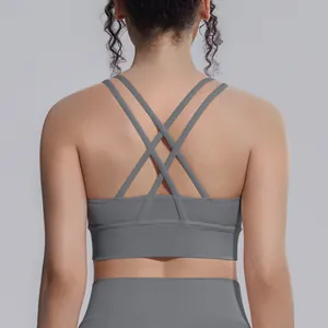 Dettaglio ravvicinato di reggiseno sportivo grigio con spalline incrociate per yoga e fitness.