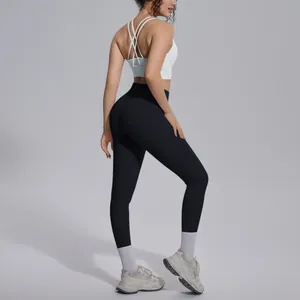 Back view of woman wearing a white cross-strap sports bra and black yoga leggings