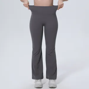 Gros plan montrant l'élasticité de la taille haute du pantalon de yoga évasé gris foncé