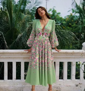 Détail en pied d'une robe mi-longue fleurie verte à manches bouffantes sur un mannequin.