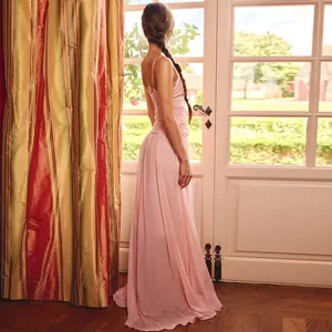 Vista posteriore di elegante abito lungo in chiffon rosa con spalline molto sottili.