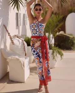 Model im blau-ethnisch bedruckten Badeanzug und passendem Sarong am Ferienort
