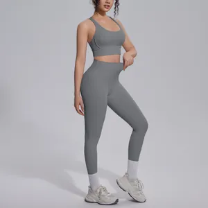 Perspective view of high-waisted leggings and sports bra set in grey nylon on a model
