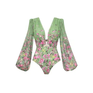 Détail d'un maillot de bain une pièce à fleurs vertes avec des manches bouffantes.