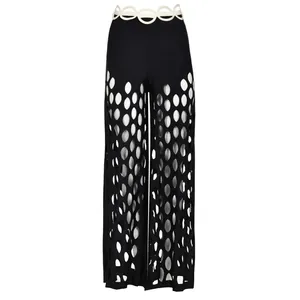 Vue détaillée du pantalon de plage noir ajouré avec une ceinture blanche décorative