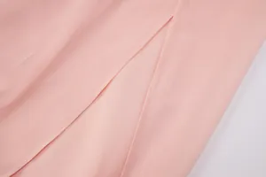 Dettaglio dell'abito in chiffon rosa con spacco sovrapposto e cuciture di qualità