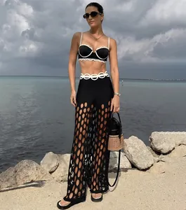 Vue détaillée du bikini noir à bordure festonnée blanche et pantalon de plage ajouré