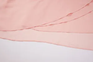 Primo piano dettagliato che mostra strati sovrapposti di chiffon rosa e cuciture dell'orlo