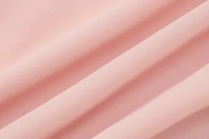 Primo piano della trama del tessuto in chiffon rosa con morbide pieghe delicate