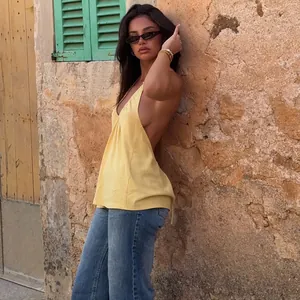 Vista laterale dettagliata di un top giallo con scollo all'americana e jeans blu casual