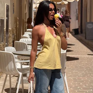 Elegante top giallo con scollo a V profondo indossato in una via molto soleggiata