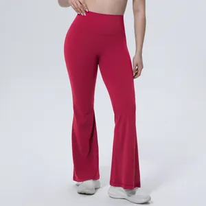 Détail montrant la coupe et la taille haute du pantalon de yoga évasé rouge sur modèle