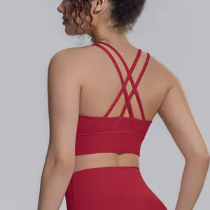 Dettaglio posteriore reggiseno sportivo rosso con spalline incrociate e leggings yoga