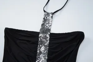 Close-up detail of silver sequins and pleated black fabric on a halter neck top for women.