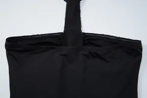 Close-up detail of a black halter neck tube top with shimmering sequin decorations.