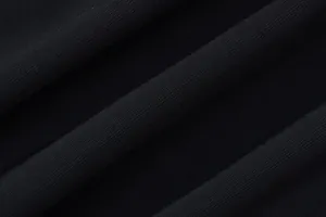 Close-up view of the black pleated fabric texture with fine vertical knitting details.