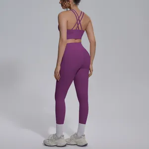 Back view of a purple nylon yoga set with a cross-strap sports bra and leggings.