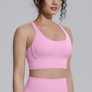 Dettaglio di un reggiseno sportivo rosa ad alto impatto in tessuto effetto nudo per lo yoga.