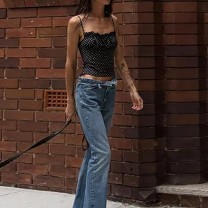 Detailed street style view of a black and white polka dot slim fit cropped camisole top for women