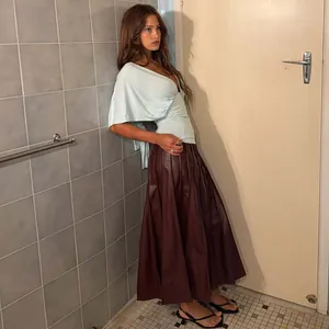 Detail view of light blue deep V-neck shawl top paired with brown pleated skirt