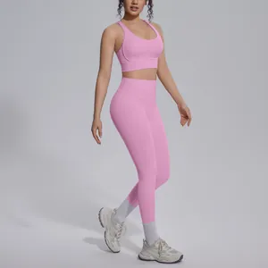 Macro view of pink cross-back sports bra and matching high-waisted yoga leggings set.