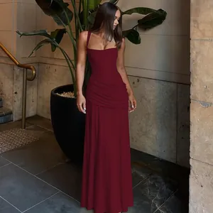 Full length view of elegant burgundy sleeveless evening gown with ruched waist detail.