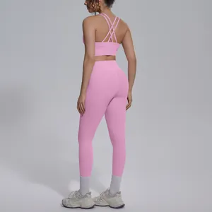 Detail of pink cross-back sports bra and matching high-waisted yoga leggings set