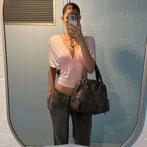 Fashionable women's pink deep V-neck crop top with drop shoulder short sleeves lifestyle view