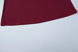 Dettaglio dell'orlo a doppia cucitura di un abito lungo sottoveste bordeaux aderente