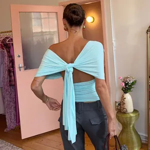 Detailed view of a light blue backless top featuring a stylish large knot tie detail.