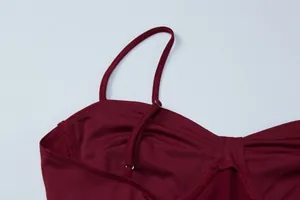 Dettaglio ravvicinato di un abito sottoveste bordeaux con sottili spalline regolabili