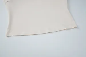 Primer plano del dobladillo con doble costura de un top entallado beige de calidad