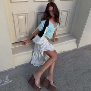 Female model outdoors wearing a stylish sky blue deep V-neck cropped short sleeve top