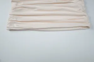 Vista detallada de la tela fruncida crema con un elegante diseño de textura plisada