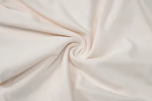 Vista macro de la textura de la tela de punto blanco crema suave para conjuntos