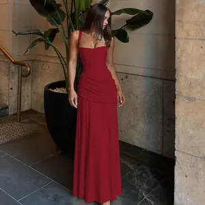 Elegant red sleeveless evening gown with ruched waist and floor-length hem detail.