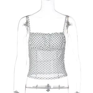 Detail view of slim fit white camisole top with black polka dot print and ruffled bust