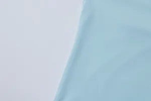 Close-up of light blue smooth fabric texture on women's summer top detail view