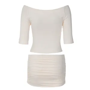 Elegante conjunto de dos piezas de top corto blanco crema con hombros caídos y minifalda