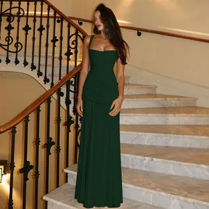 Elegant dark green sleeveless evening gown featuring a ruched waist on marble stairs