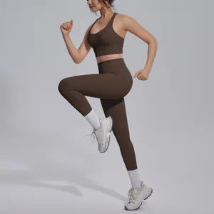 Athletic woman wearing coffee brown yoga set with leggings and sports bra in studio